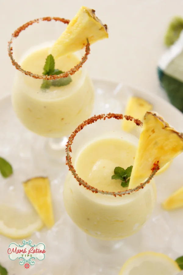 Margarita de piña congelada en un vaso con una ramita de menta