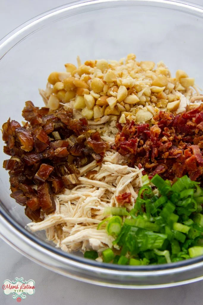 pollo deshebrado dátiles, macadamias, tocino y cebollin picado en un bowl